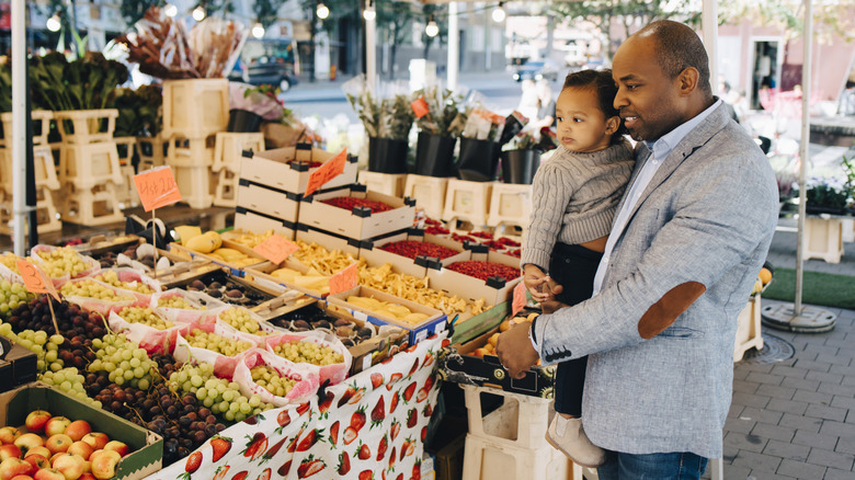 Father and child at a fruit stall