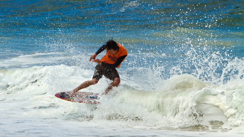 Man skimboarding in the waves a Laguna Beach, California