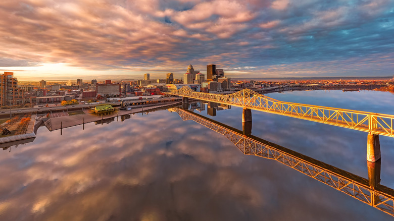 Aerial view of Louisville with a red and dark sky in the background, a bridge in the foreground.