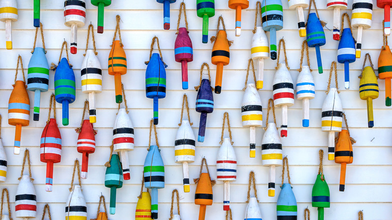 An art installation of colorful lobster floats hung on a white wall
