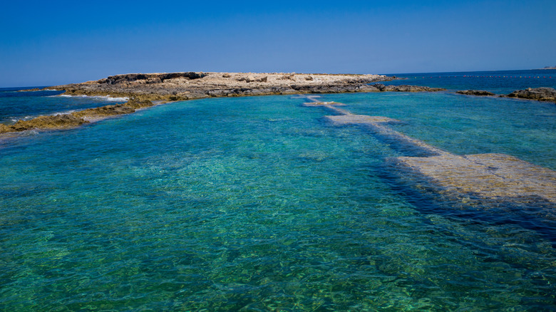 A rocky swimming spot with clear blue water in Qawra, Malta