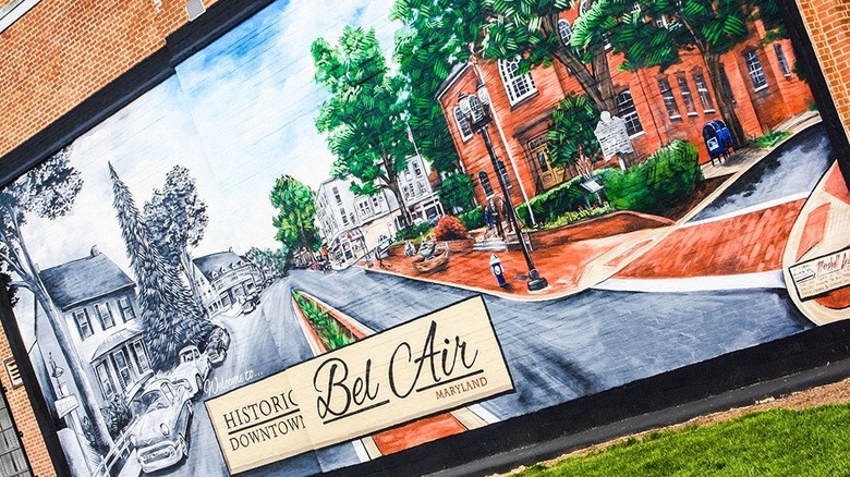 Mural of downtown Bel Air with the left half in black and white and the right in color, on a brick wall