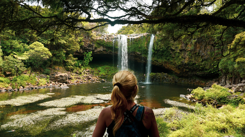Back of blonde woman looking from viewpoint at Rainbow Falls