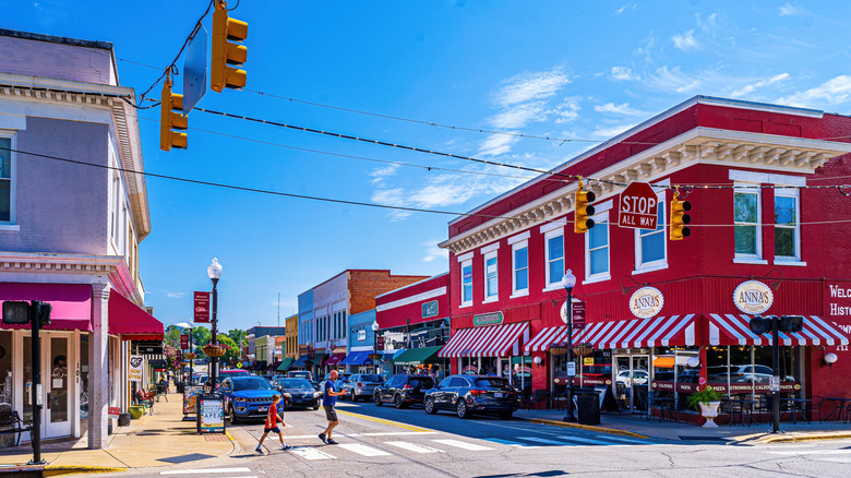 Two silhouetted figures cross the street in downtown Apex, North Carolina during the daytime