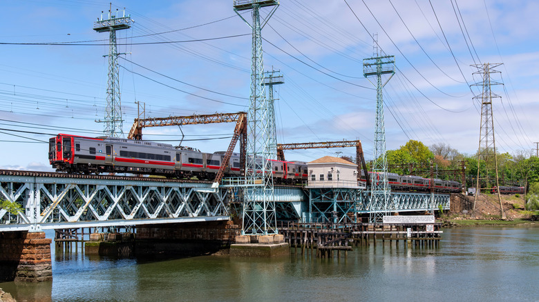 Train going over Mianus River on the Cos Cob bridge in Connecticut during the day.
