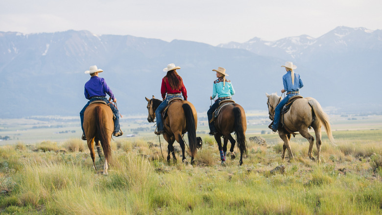 Four people on horseback with mountains