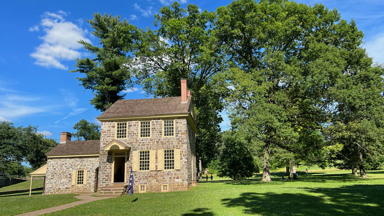 Valley Forge National Historical Park and a historic brick home in front of scattered trees.