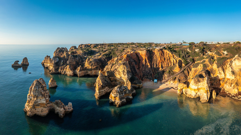 Aerial view of rocky coastline and Praia do Camilo beach hidden cove