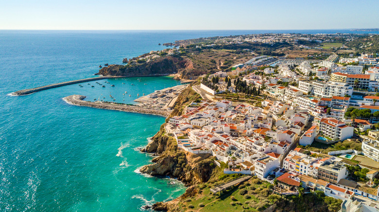 Aerial view of Albufeira city with its rocky oceanfront cliffs, marine and secluded beaches.