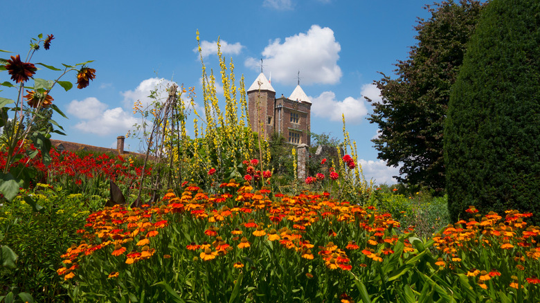 A flowerbed with the tower of Sissinghurst Castle in the backdrop