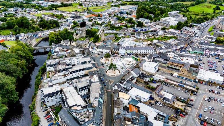 Buildings and cars in town near river with trees