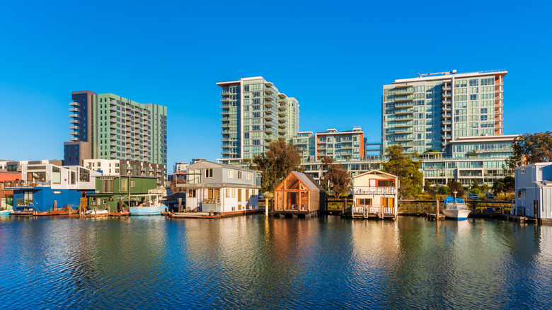 Houseboats on Mission Creek Channel in Mission Bay district in San Francisco, California, USA. Newly developed apartment flats in the background