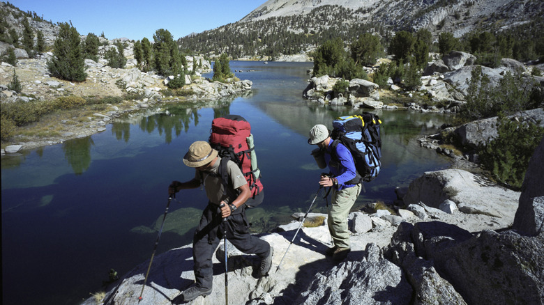 two backpackers hike beside one of the Rae Lakes in Sequoia Kings Canyon National Park