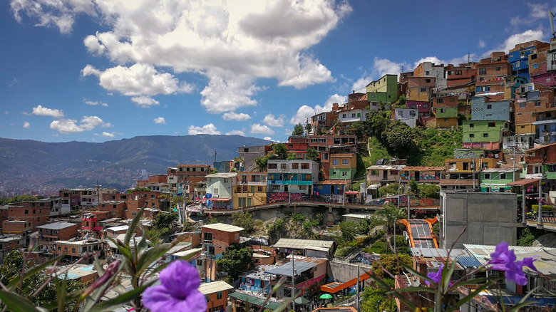 Colorful hillside neighborhood under a partly cloudy sky in Comuna 13
