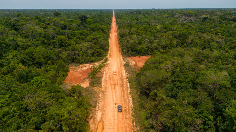 a car driving on a dirt road through the Brazilian Amazon in the dry season