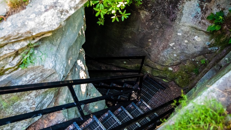 Metal steps leading down to a dark rock cave, Devil's Kitchen