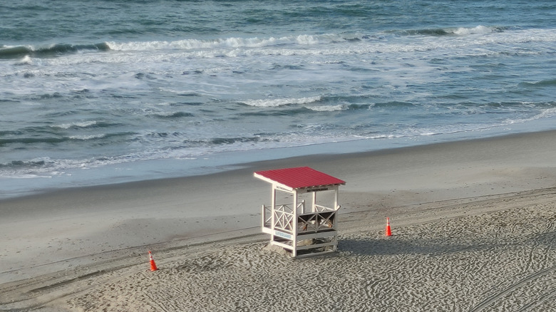 Lifeguard post with red roof on empty South Carolina beach with traffic cones nearby
