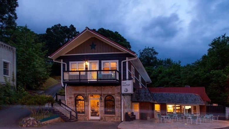 Trout Mountain Inn in Tellico, Plains, TN, at dusk, with lights glowing from inside.