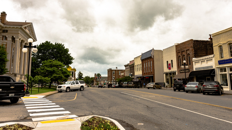 View of downtown Pulaski, Tennessee during an overcast day with cars parked along the street in front of business buildings.