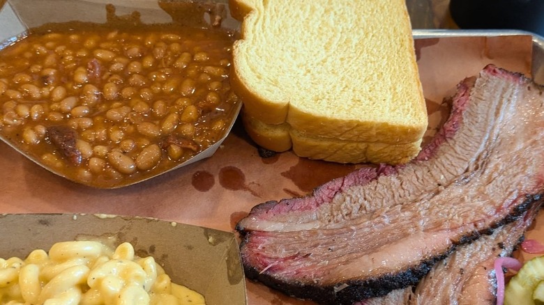 Beans, bread, macaroni & cheese, and brisket on a platter