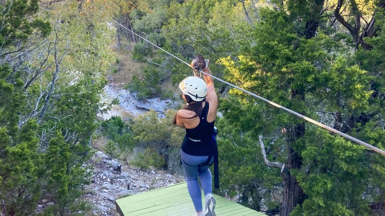 A woman holding on to a zipline rope
