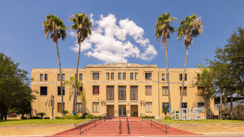 Imposing Starr County Courthouse with palms and blue sky