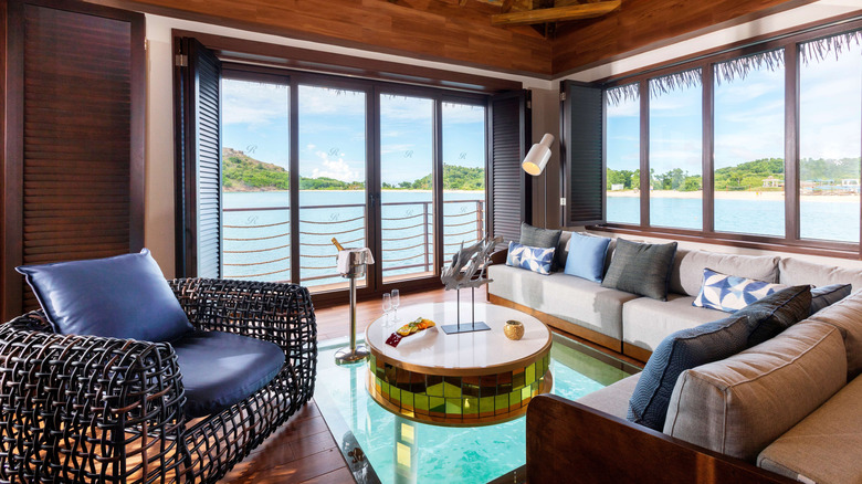 Interior view of the living area of one of the Chairman Overwater Bungalows at the Royalton Antigua, a five-star resort on Antigua's Deep Bay
