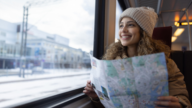 A woman holding a map while traveling on a train