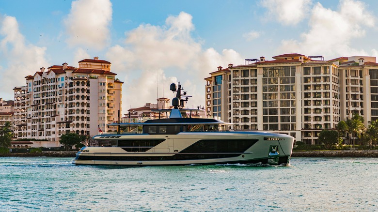 Luxury yacht sailing past buildings on Fisher Island, Florida