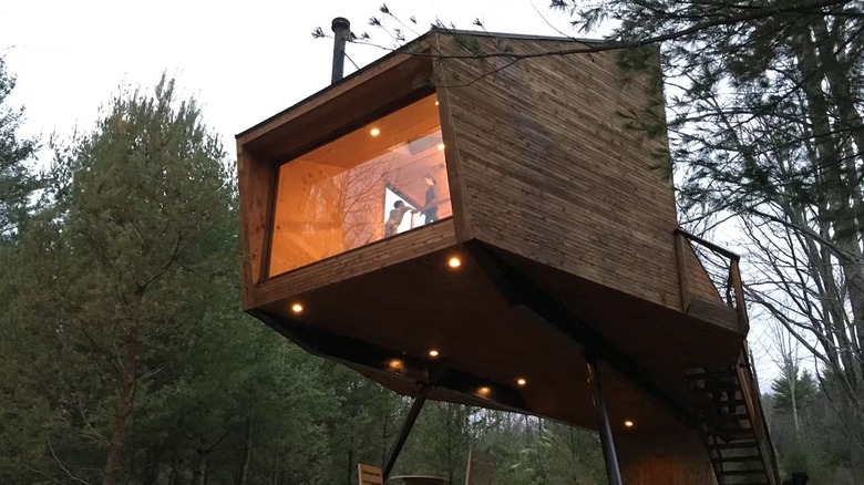 A panoramic window wall looks out over the pond at the Willow Treehouse in the Catskills.