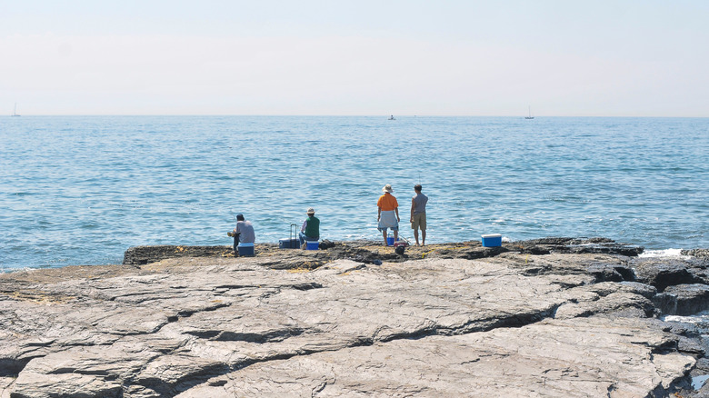 People fishing off the rocks at Brenton Point State Park