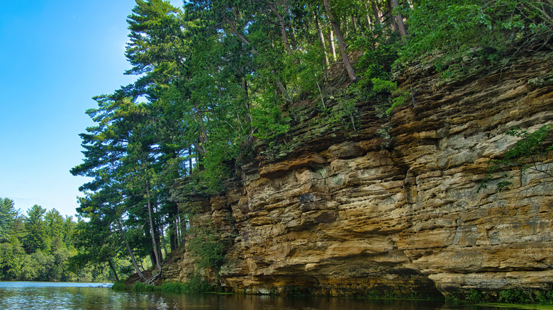 Closeup of sandstone cliffs and a forest along the banks of Mirror Lake in Wisconsin