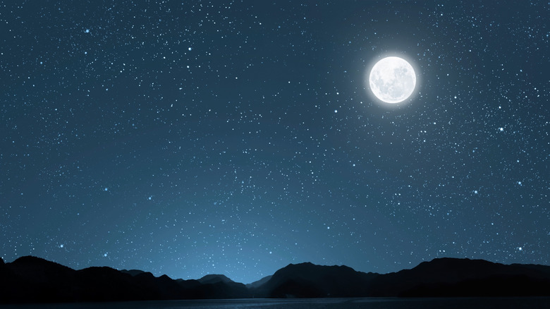 A starry night sky over the silhouette of mountains