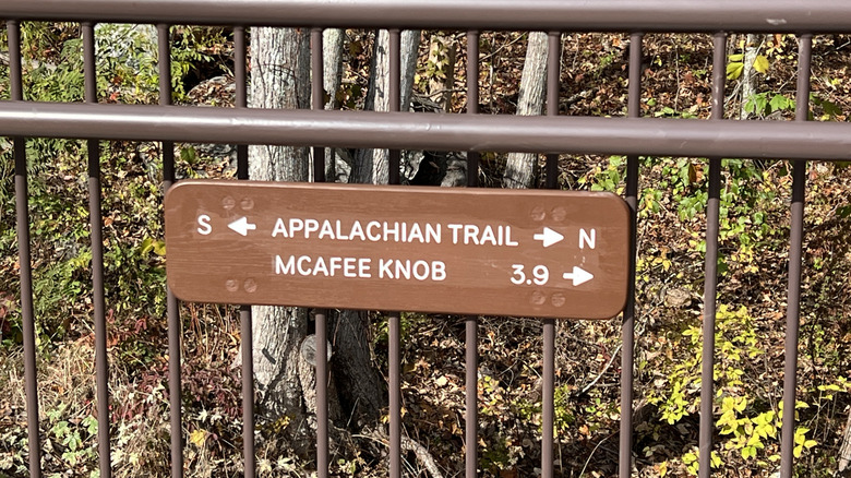 directional sign on fence at trailhead for Appalachian Trail and pointing toward McAfee Knob