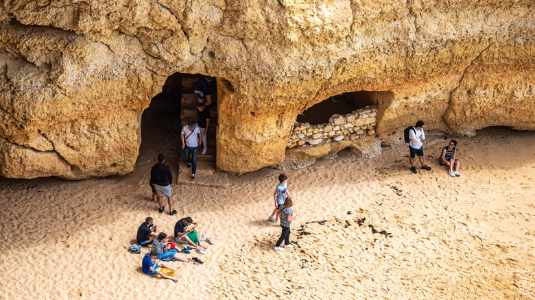 Hikers resting at the Benagil Coves along the Algarve coast.