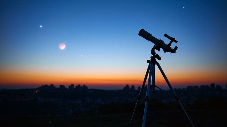Telescope pointed to the sky with setting sun