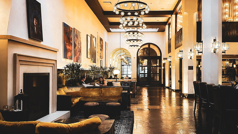 View of Hotel Figueroa's lobby with couches, book cases, and long corridor in background