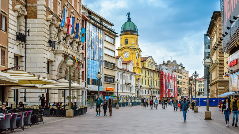 View of the City Clock Tower and Korzo, the main promenade filled with shops, cafes, and walking tourists, in the town of Rijeka in Kvarner Bay, Croatia, on a sunny day