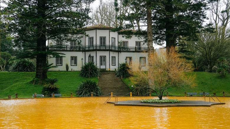 Botania Hall stands on a small green hill behind the orange-colored thermal bath at Terra Nostra Park