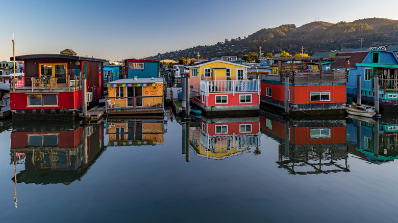 Sausalito houseboats on the water with rolling hills in background.