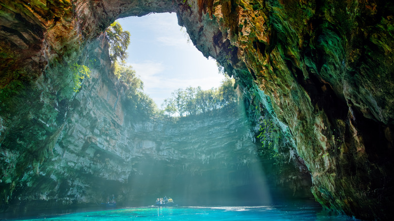 Sunlight streams down on boaters in Melissani lake on Kefalonia island, Greece