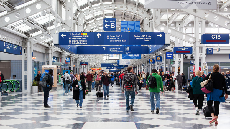 People walk through busy Chicago O'hare airport terminal