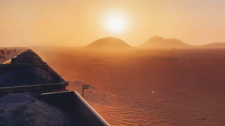 Carts of the iron ore train in Mauritania with monoliths visible in the distance