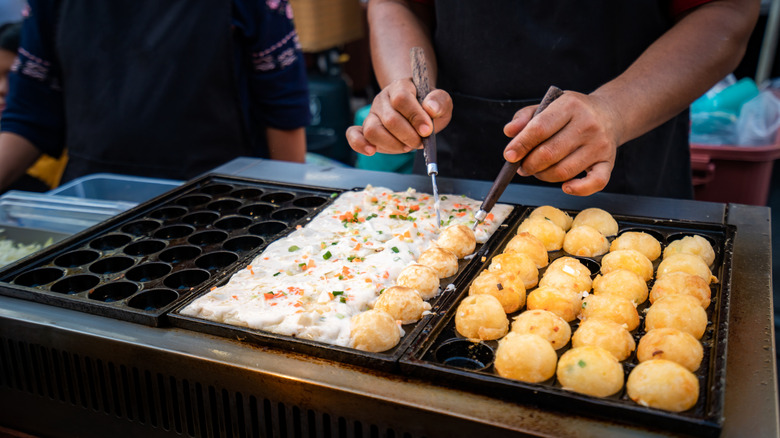 Chef cooking Osaka's famous Takoyaki on a hot pan