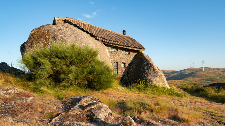 House between two boulders at sunset