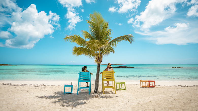 Couple sitting in chairs on the beach at Cape Santa Maria Resort, Bahamas
