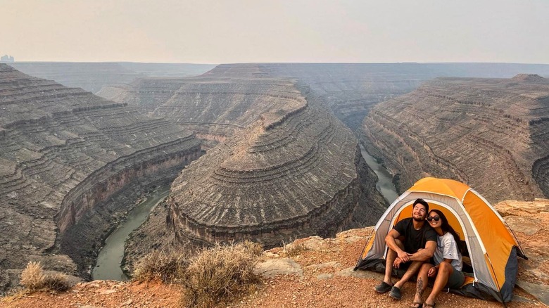 Couple camping on cliff edge