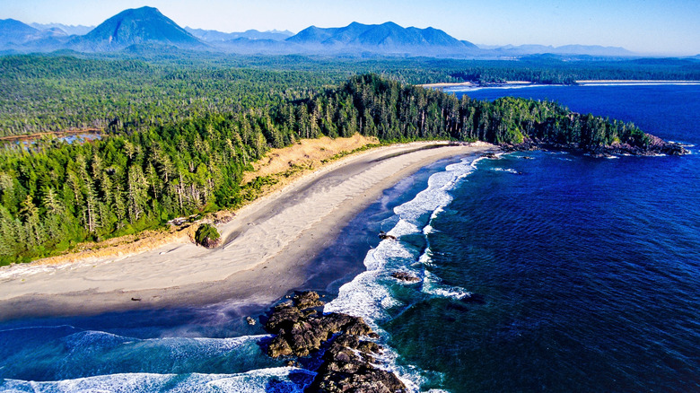 A beach on Vancouver Island's Pacific coastline with mountains in the distance