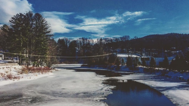 a thawing river with snow-covered banks in Springfield, Vermont