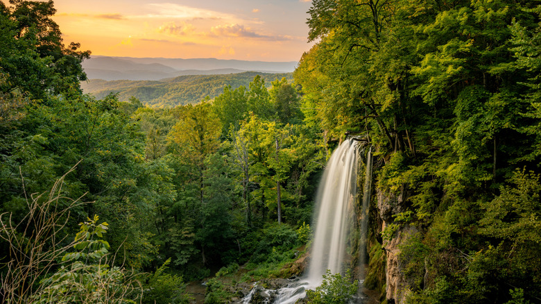 A landscape view of Falling Spring Falls Waterfall in Virginia under sunset sky